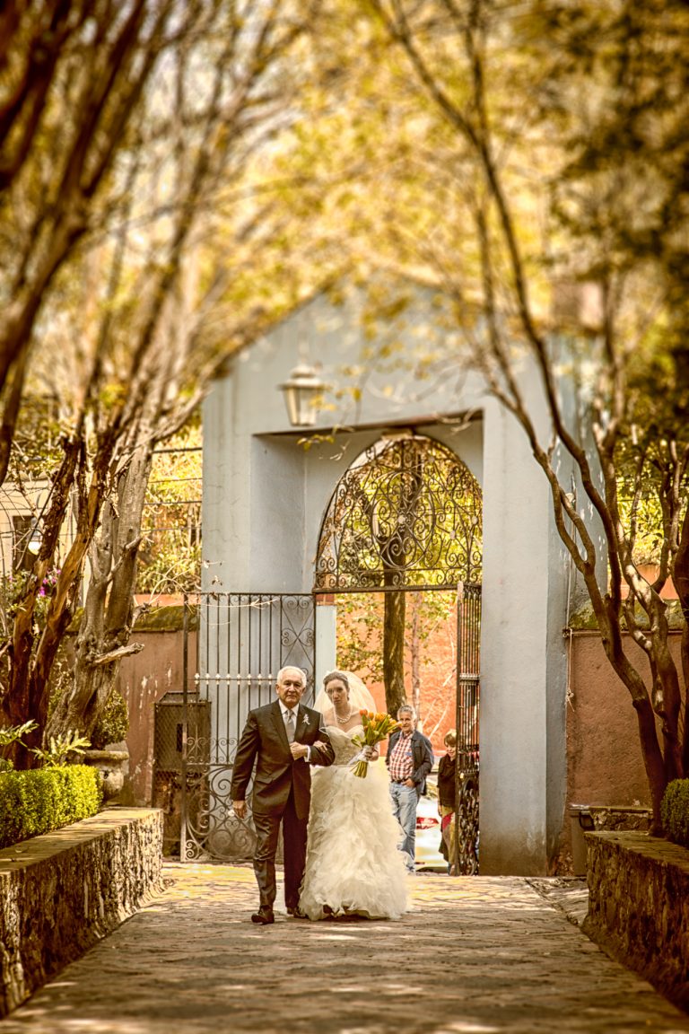 una novia y un novio caminando por un sendero.